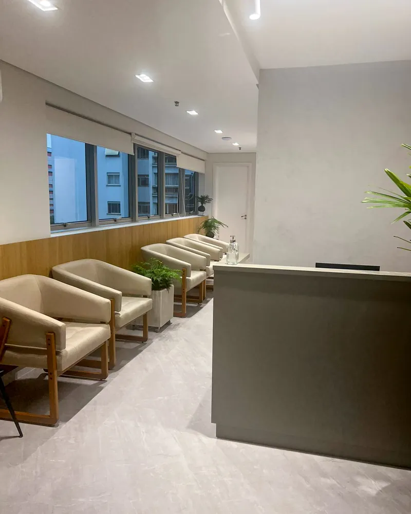 Sala de espera com poltronas claras e janelas